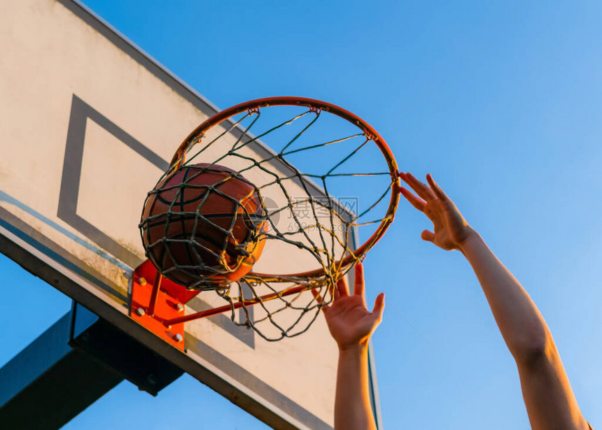 街头篮球扣篮大赛球落入篮筐的特写都市青年游戏成功得分图片