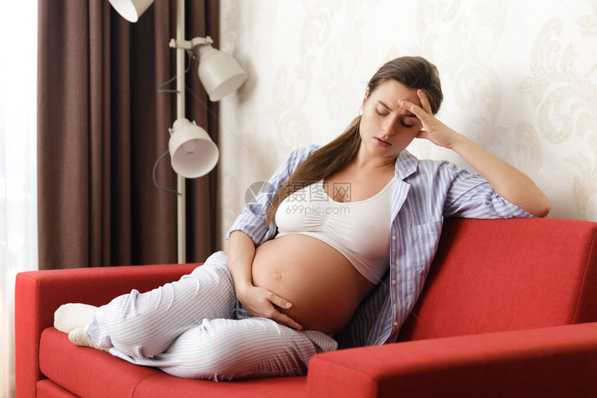 躺在沙发上的年轻孕妇在家头痛地头痛图片