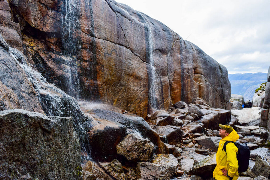 观光客看到瀑布从靠近Kjeragbolten的悬崖落下图片