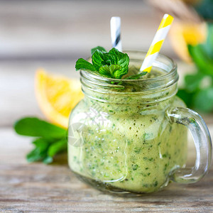 用菠菜香蕉橙子和薄荷放在玻璃罐和配料的罐子里自制绿色冰沙排毒饮食健图片