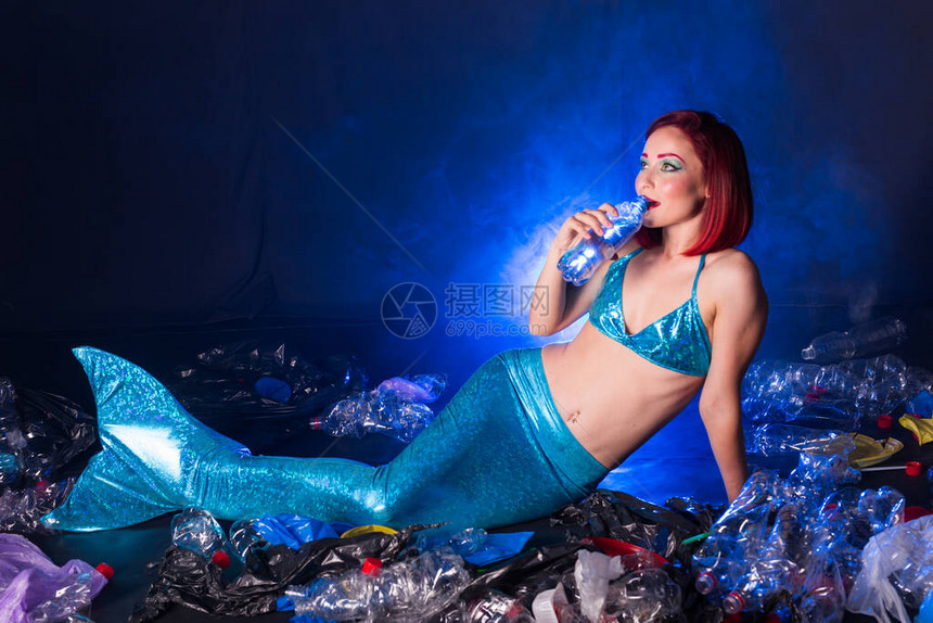 深海中奇幻的愚蠢的美人鱼塑料水瓶和袋对海底的污图片