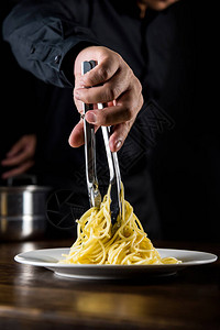 厨师在厨房的餐桌上烹制传统意大利面图片
