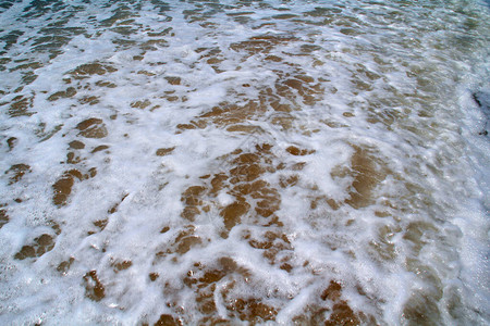 大浪和冲浪后沙滩上的海白色泡沫图片