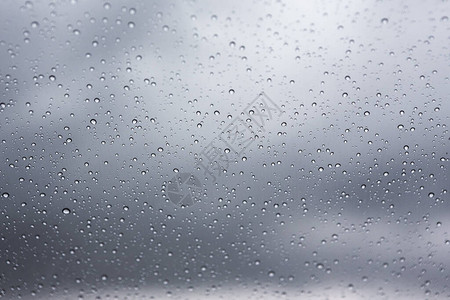 车窗玻璃上的雨滴和雨云背景图片