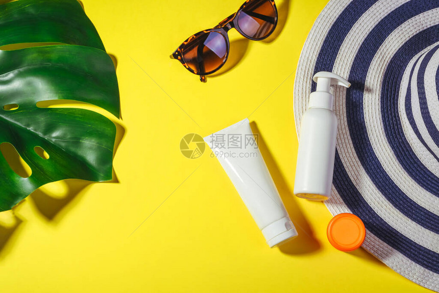 防晒物品带太阳眼镜和保护霜spf30顶视图的稻草女人帽子在明亮的黄色背景上海滩配件夏季旅游度假概念销售套图片