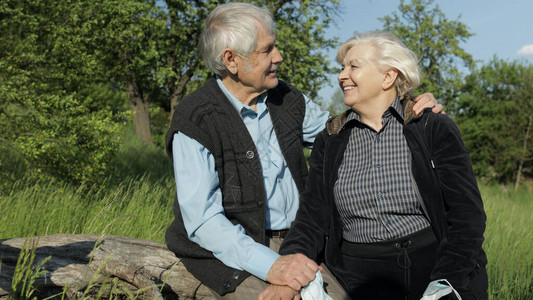 年长的祖父母夫妇坐在公园里图片