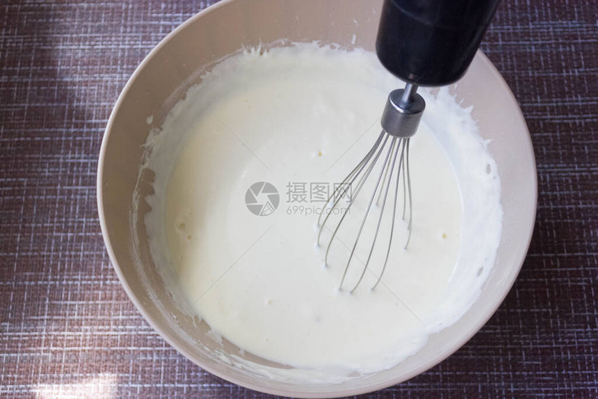 在厨房用搅拌器在碗中制作煎饼或煎蛋卷的面团用白软干酪制成的自制健康煎饼煎饼说明一步第1步图片