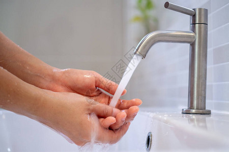 妇女在浴室里打开水洗手图片