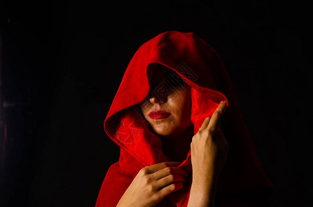 穿着红色斗篷的身穿深色背景的红袍子戏剧图片