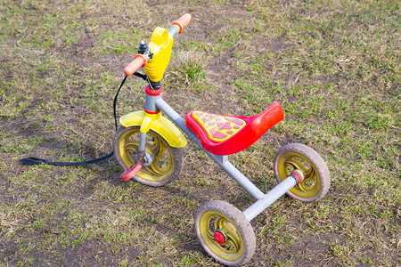 一辆三轮儿童自行车站在草地上图片