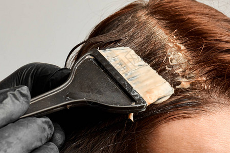 用黑梳子染发给女人的理发师布鲁内特图片