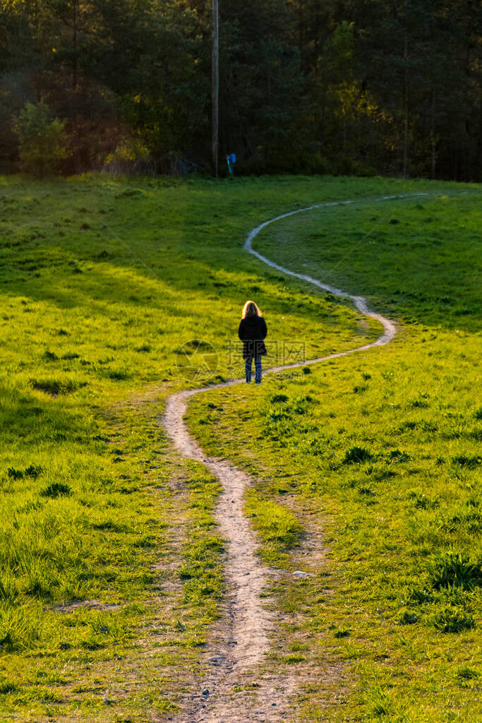 瑞典斯德哥尔摩Ekero郊区的一个女人在日落时走下一图片