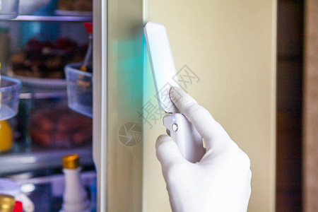 使用消毒装置对冰箱门进行消毒图片