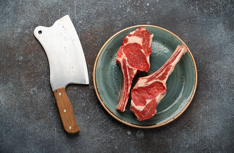 盘子上两块生的大理石战斧肉牛排背景图片