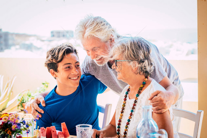 白种人不同年龄和代相传祖父和孙子一起在餐桌边的家里吃图片