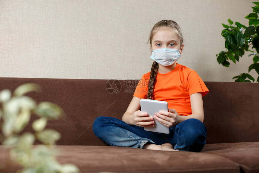 身戴医疗面具的小女孩坐在莲花位置沙发上图片