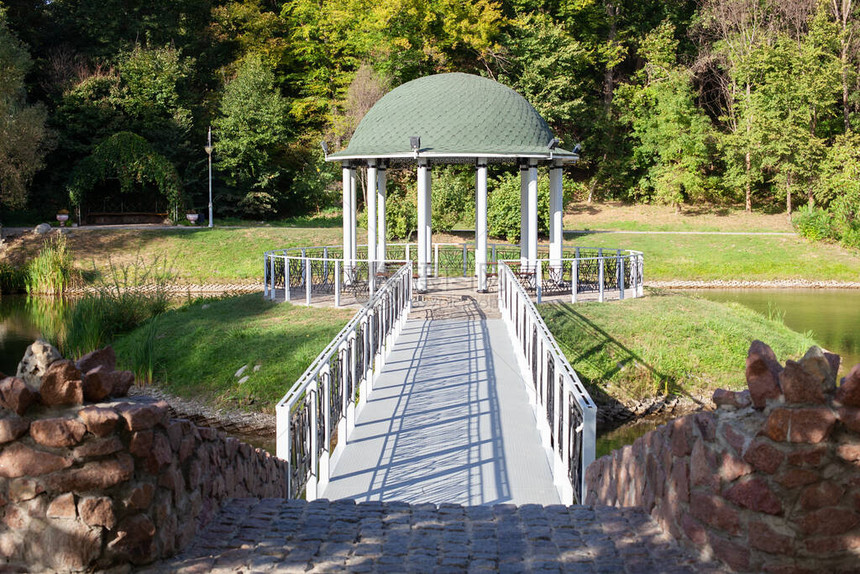 美丽的公共花园公的亭子白色凉亭森林景观有锻造桥梁池塘和夏天风景背的室外凉亭河边孤独的凉亭绿图片