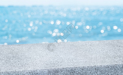 具有模糊海天波克背景的空对角灰色鹅卵石桌图片