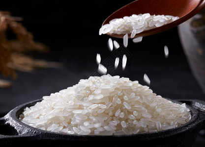 米饭背景上的木勺米饭图片