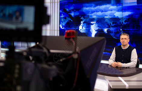广播工作室的男新闻主播在电视演播室的Teleprompter摄像图片