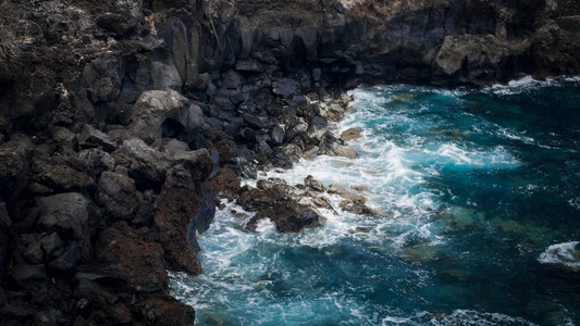 蓝色海洋波浪的海景在黑火山岩石和海图片