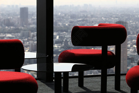 现代咖啡桌排在摩天大楼休息室的窗户旁边图片