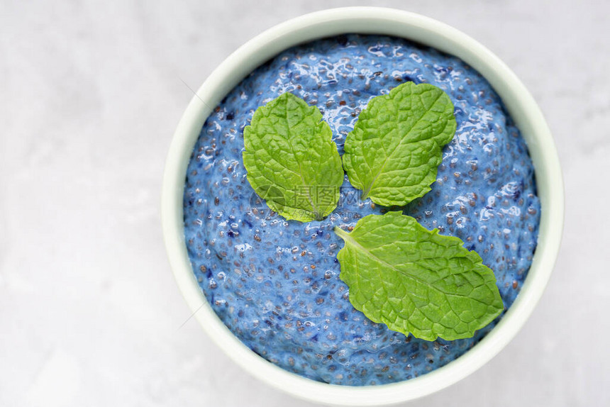 蓝色螺旋藻或蝴蝶豌豆花蓝色抹茶粉奇亚籽布丁装在瓷碗里图片