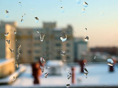 城市景观背景上的窗玻璃上的冰冻水滴图片