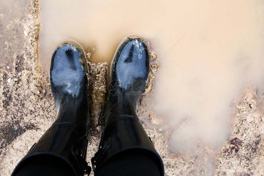 站在泥泞中的黑色靴子图片