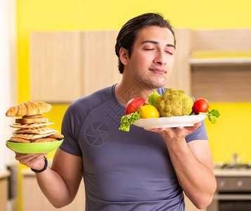 男人在健康饮食和不健康食物之间图片