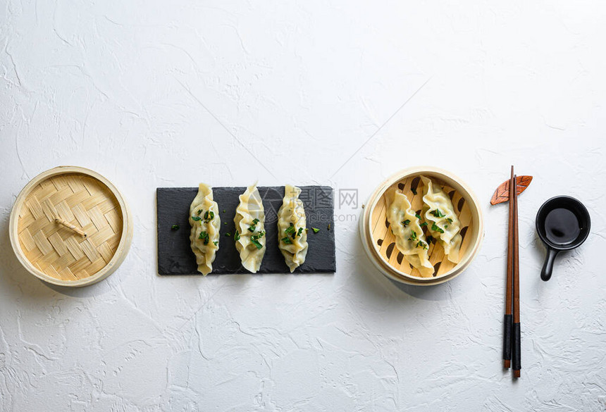 小吃蒸饺传统美食概念竹蒸笼中的饺子点心与文本复制空间白色背景图片