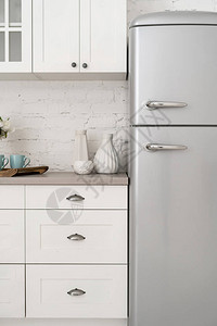 现代室内风格碎片现代的垂直照片新冰箱台面上的白色装饰花瓶图片