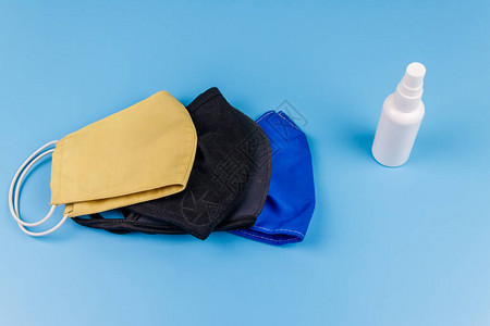 一套蓝色背景的可再用织物面罩和手洗净剂图片
