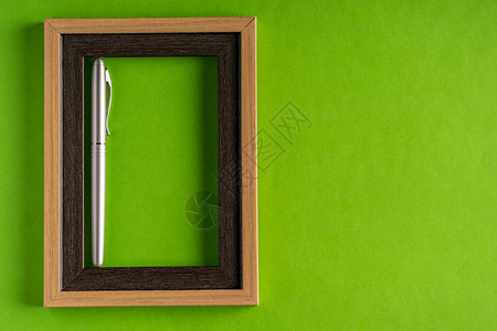 绿色背景下的经典银笔和空框以绿图片