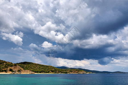 从海上看岸边与大海和美丽的云彩在蓝天的风景Sithonia图片