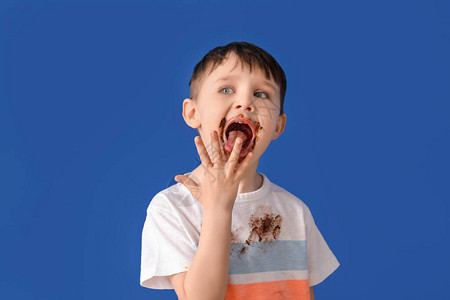穿脏衣服的小男孩吃巧克力的图片