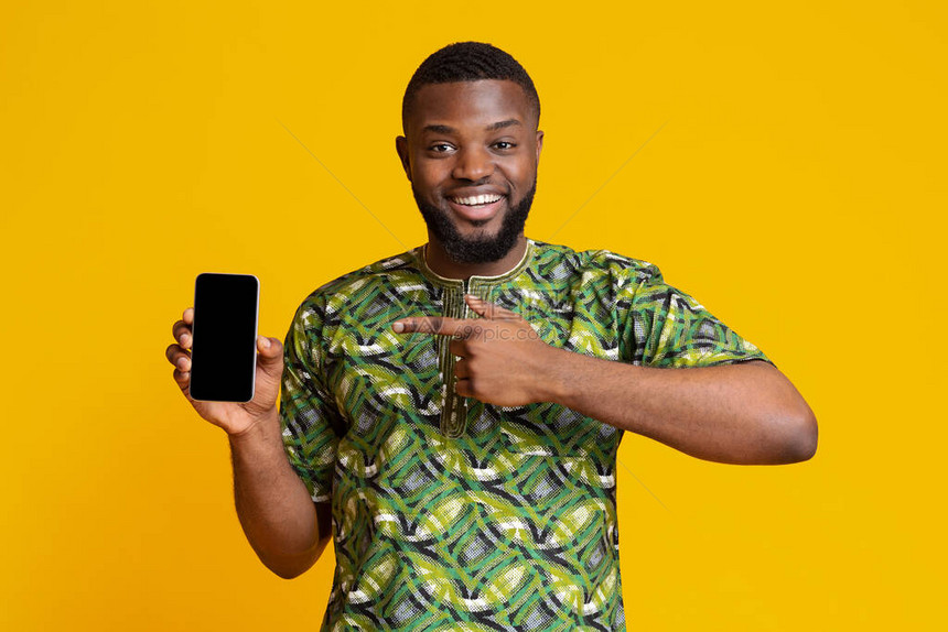 指着空智能手机屏幕推荐新应用程序黄色背景的非洲快乐男子info图片