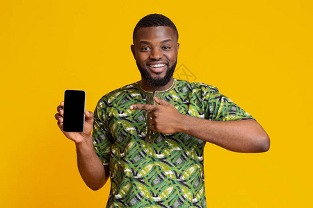 指着空智能手机屏幕推荐新应用程序黄色背景的非洲快乐男子info图片