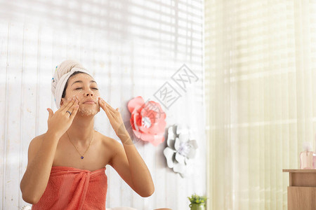 女人在房间里用毛巾敷面膜图片