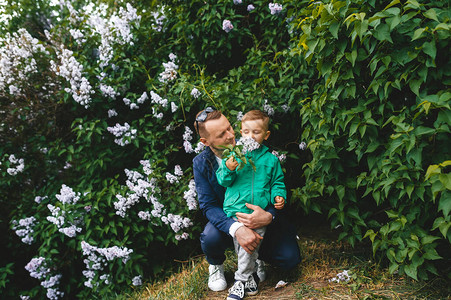 爸拥抱小儿子在花园里欢笑小男孩喜欢闻图片