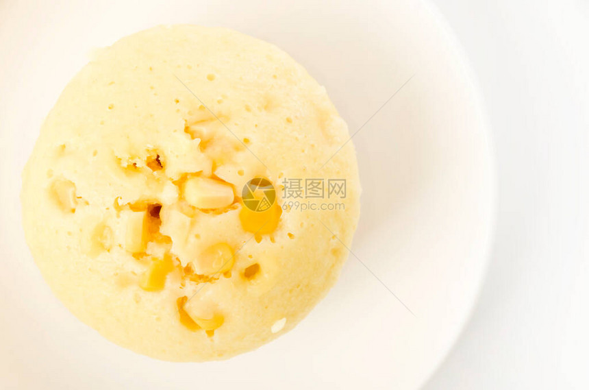 白色背景上的白盘子上的玉米蒸糕图片