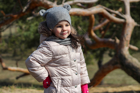 穿着戴耳朵和围巾的帽子的可爱小女孩在森林中秋天散图片