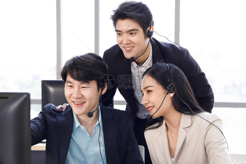 三个快乐的亚洲呼叫中心接线员一起工作图片