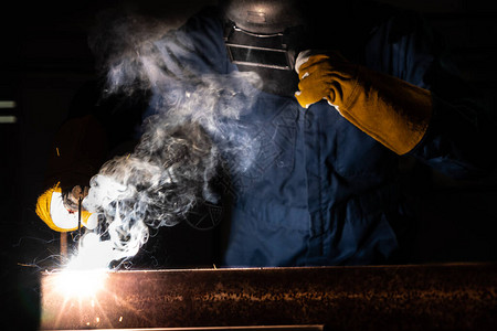 金属焊工使用电弧焊机在工厂焊接钢背景图片