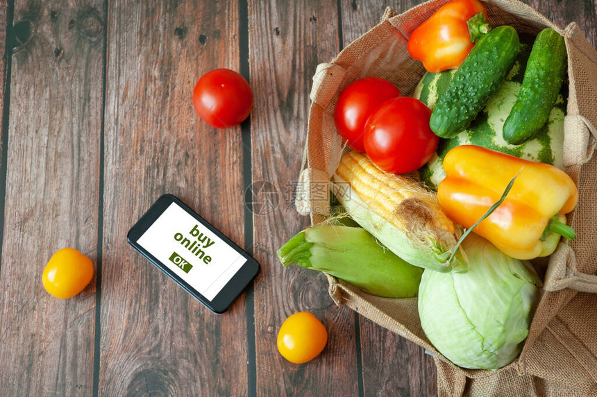 有机蔬菜和水果装在棉袋和手机中图片