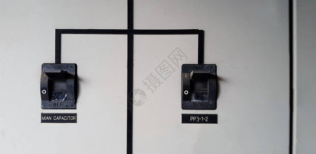关闭两个黑色电气主断路器在灰色或灰色不锈钢柜上相互连接图片