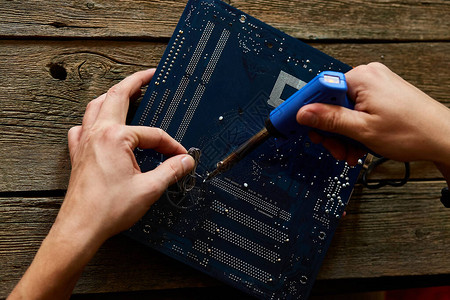 工程师或技术人员用烙铁修理电子路板男子手士兵使用烙铁的计算机电路图片