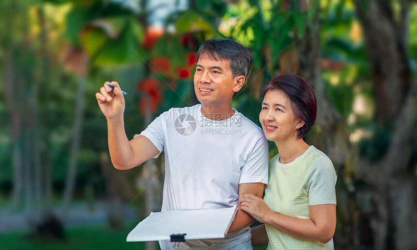 亚洲中年夫妇在后院一起交谈和设计花园计划图片