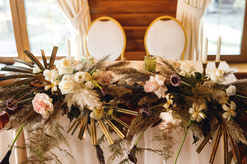 新婚夫妇在婚礼上的主席团新娘和新郎在餐厅用鲜花的表新婚夫妇的宴会桌关闭图片