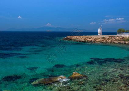 有地中海清蓝水域和古老的小型灯塔背景图片